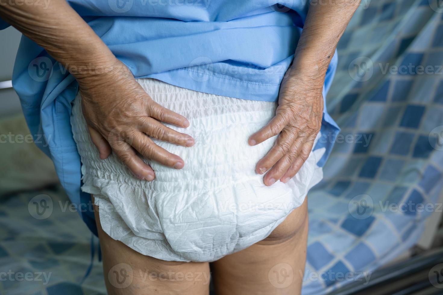 Paciente asiático mayor o mayor de la mujer de la señora mayor que lleva el pañal de la incontinencia en la sala del hospital de enfermería, concepto médico fuerte sano. foto