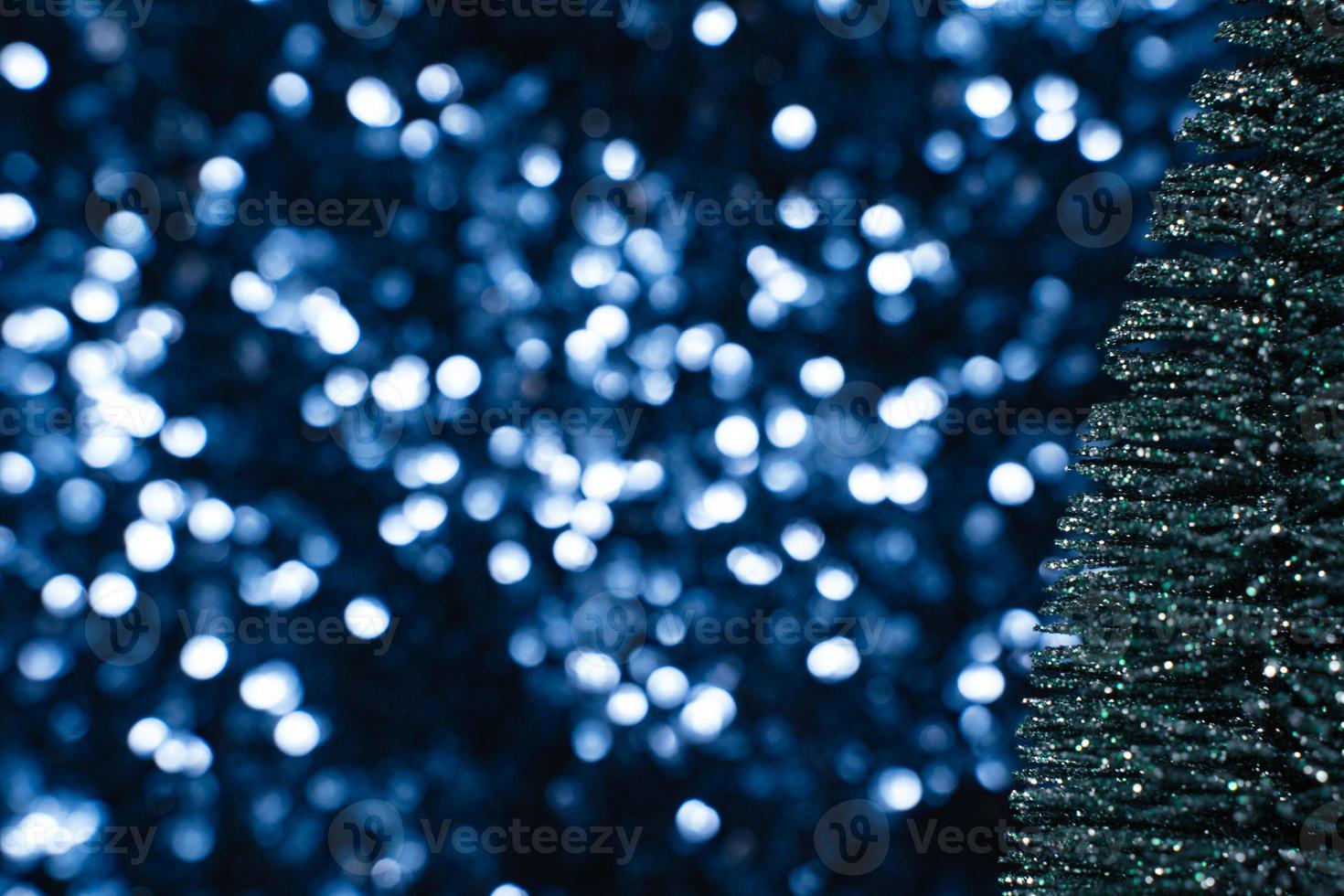 árbol de navidad de brillo verde sobre fondo de lentejuelas azul foto