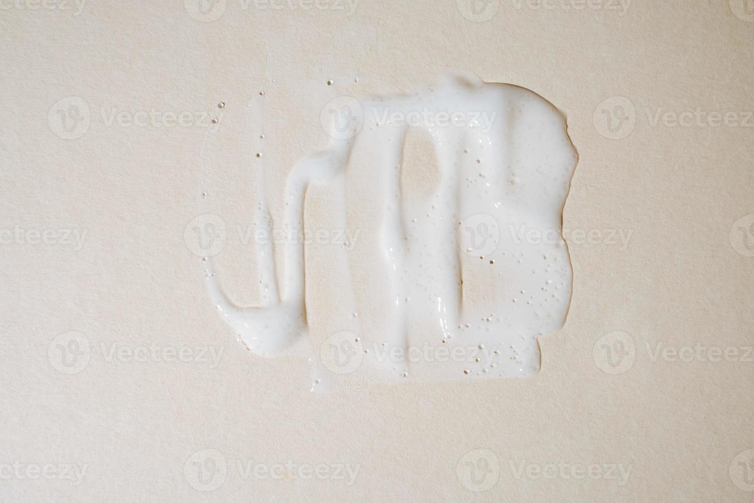 White cream with beads on beige background photo
