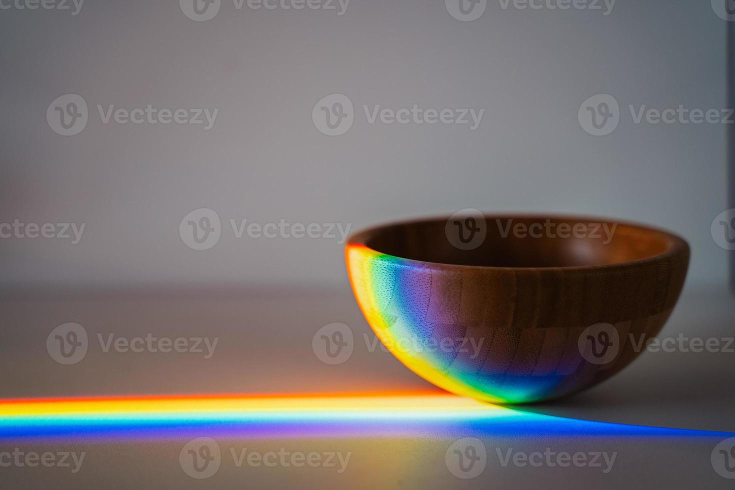 wooden bowl on grey background with rainbow light photo