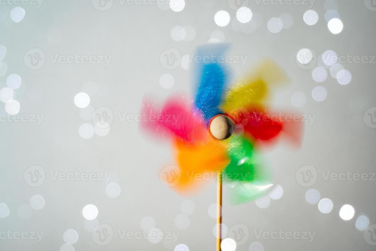 Colorful turning pinwheel on shiny white background photo