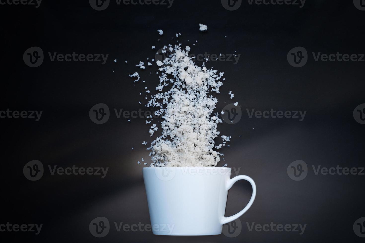 Blank white ceramic mug on black background with coconut flakes and glitter photo