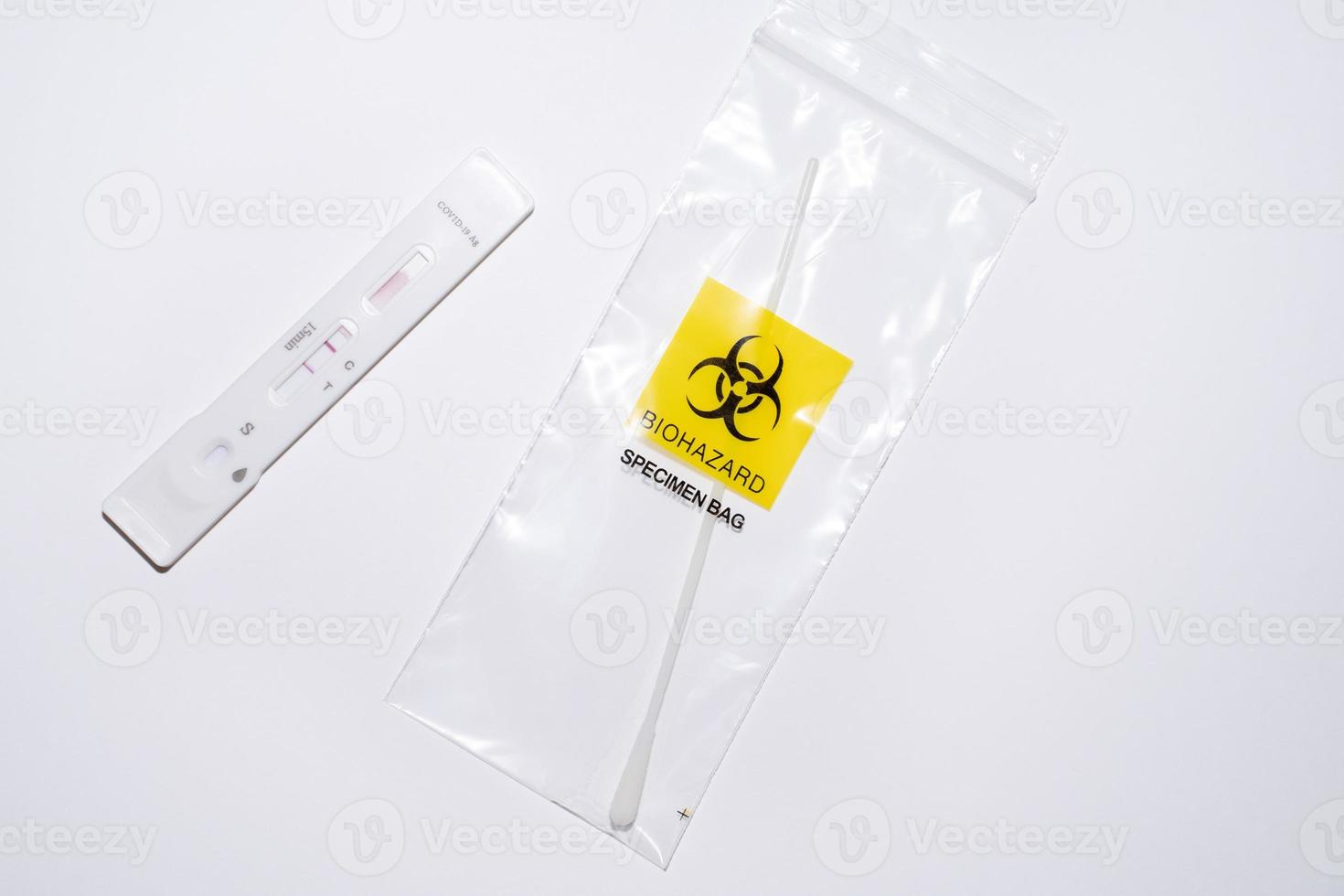 Positive covid self-test and swab in biohazard bag photo
