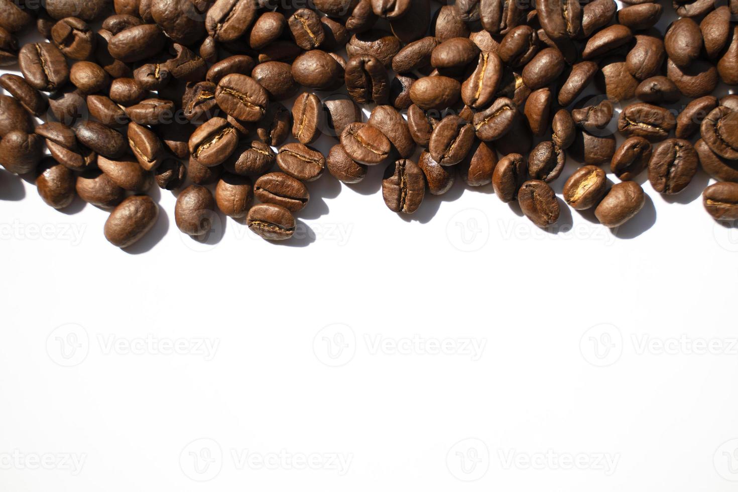 Isolated roasted coffee beans in harsh light photo