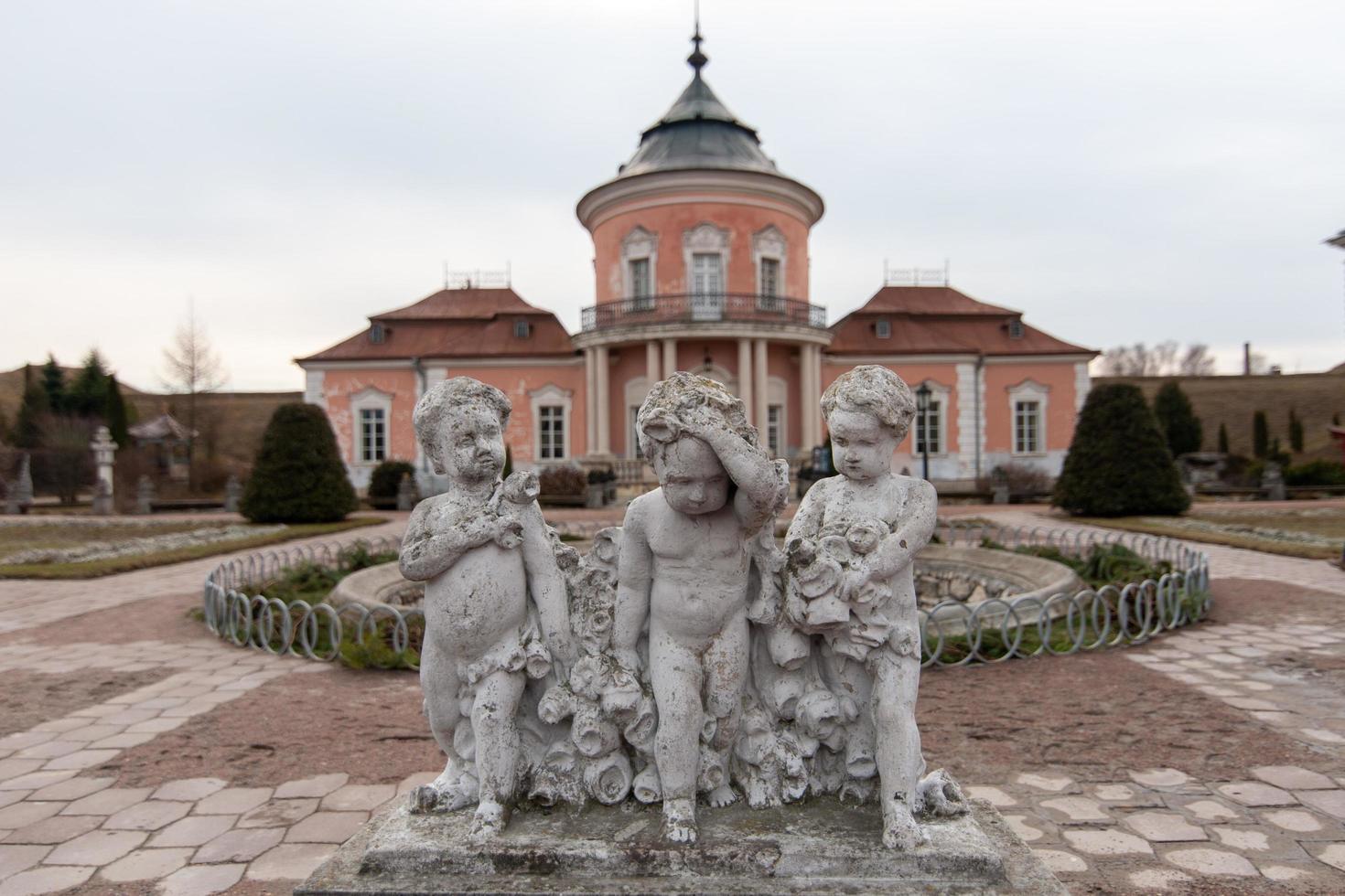 tres estatuas de niños frente al castillo polaco, en el territorio de la ucrania moderna. foto