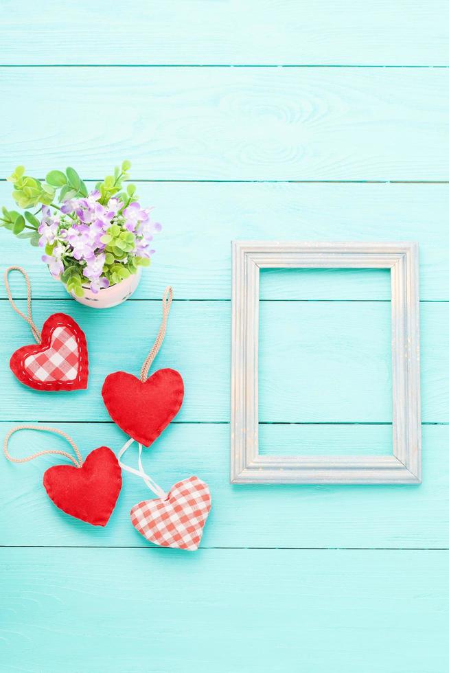 Valentine's accessories with heart shapes on blue wooden table. Top view. Mock up for text. photo