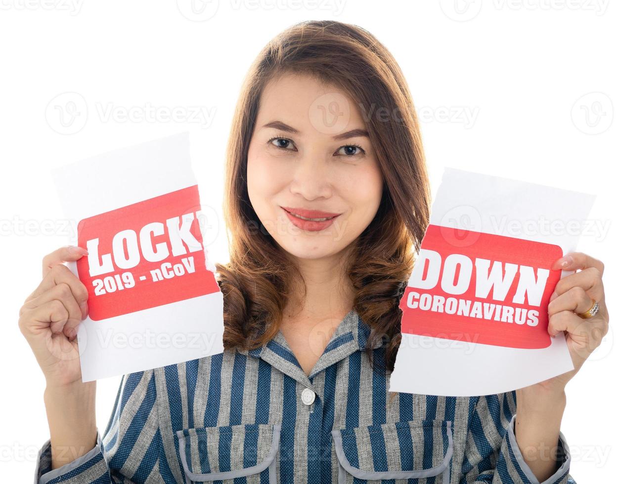 Woman shows happy face between pieces of torn paper with Covid-19 lockdown announce words. The idea or concept for the ending, happiness and free after finishing and recovered from Coronarivus photo