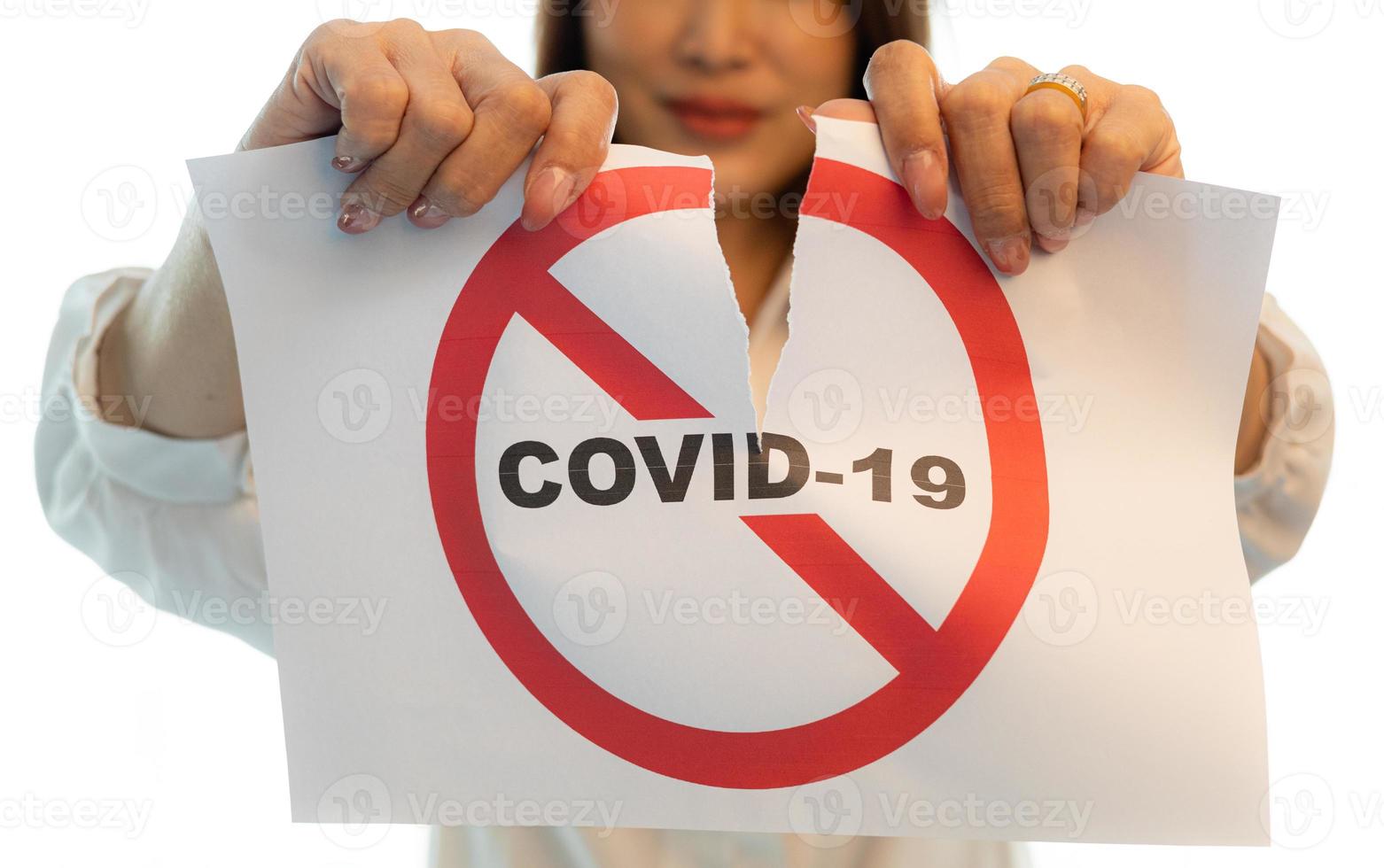 Woman holding and tearing paper with Covid-19 coronavirus warning words. The idea or concept for the ending, happiness and free after finishing and recovered from Coronarivus, on white background photo