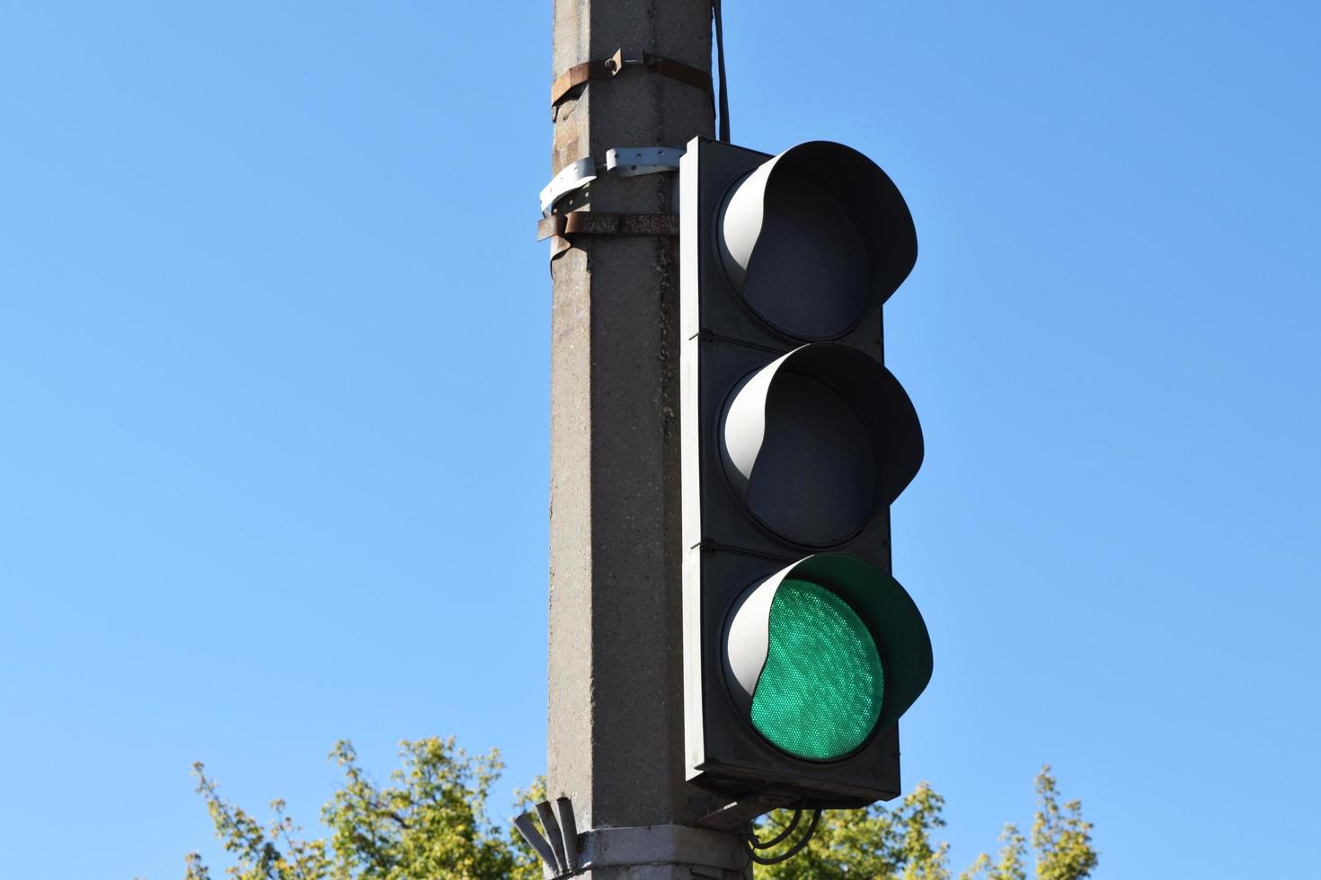 street tricolor traffic light with green light on photo