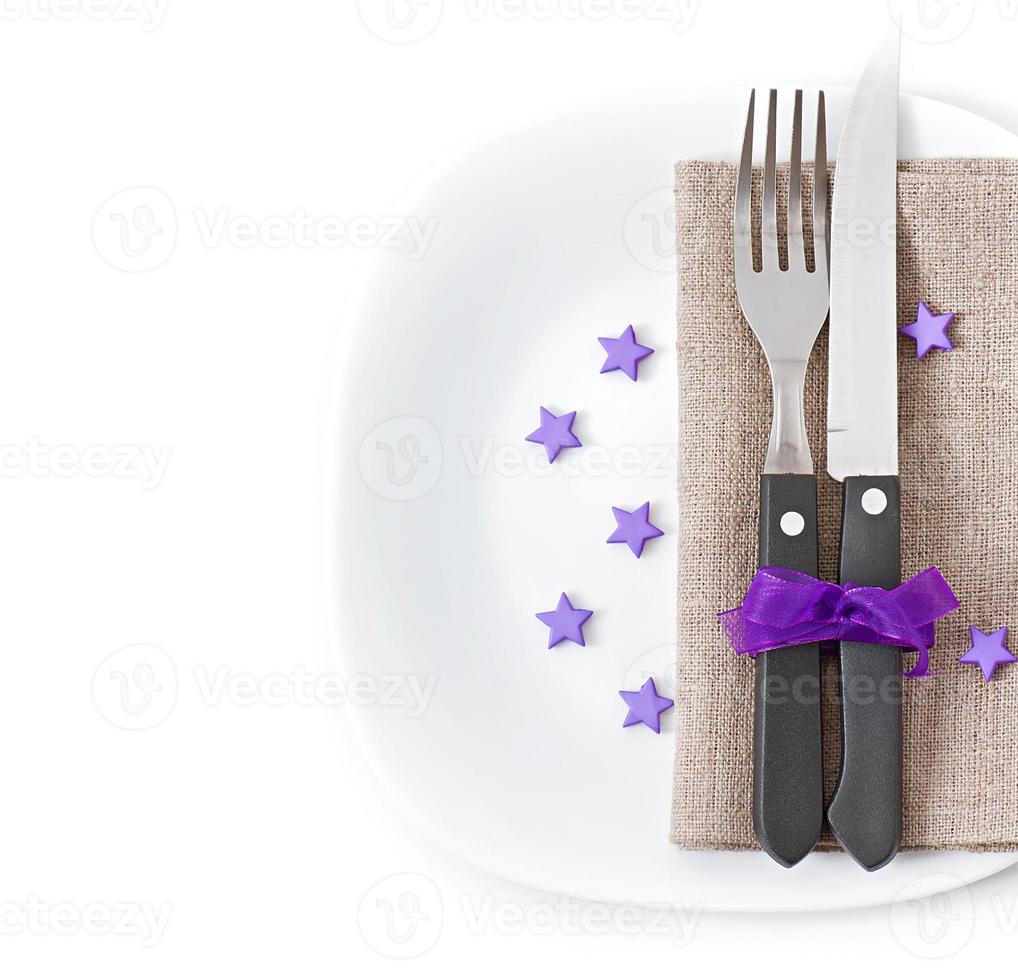 Close up of a knife and fork on a white plate with napkin photo