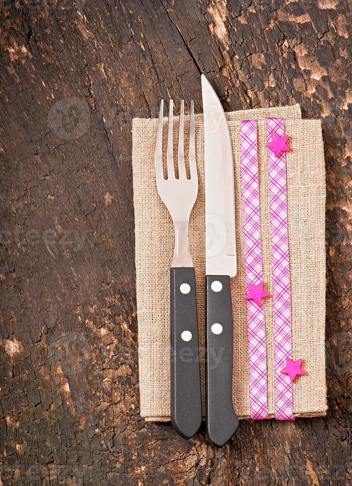 Close up of a knife and fork on a white plate with napkin photo