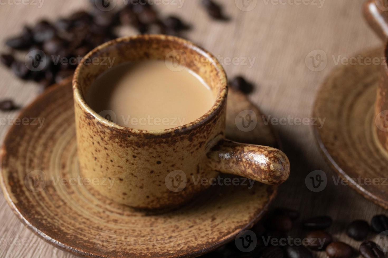 café caliente en taza marrón sobre fondo de madera foto