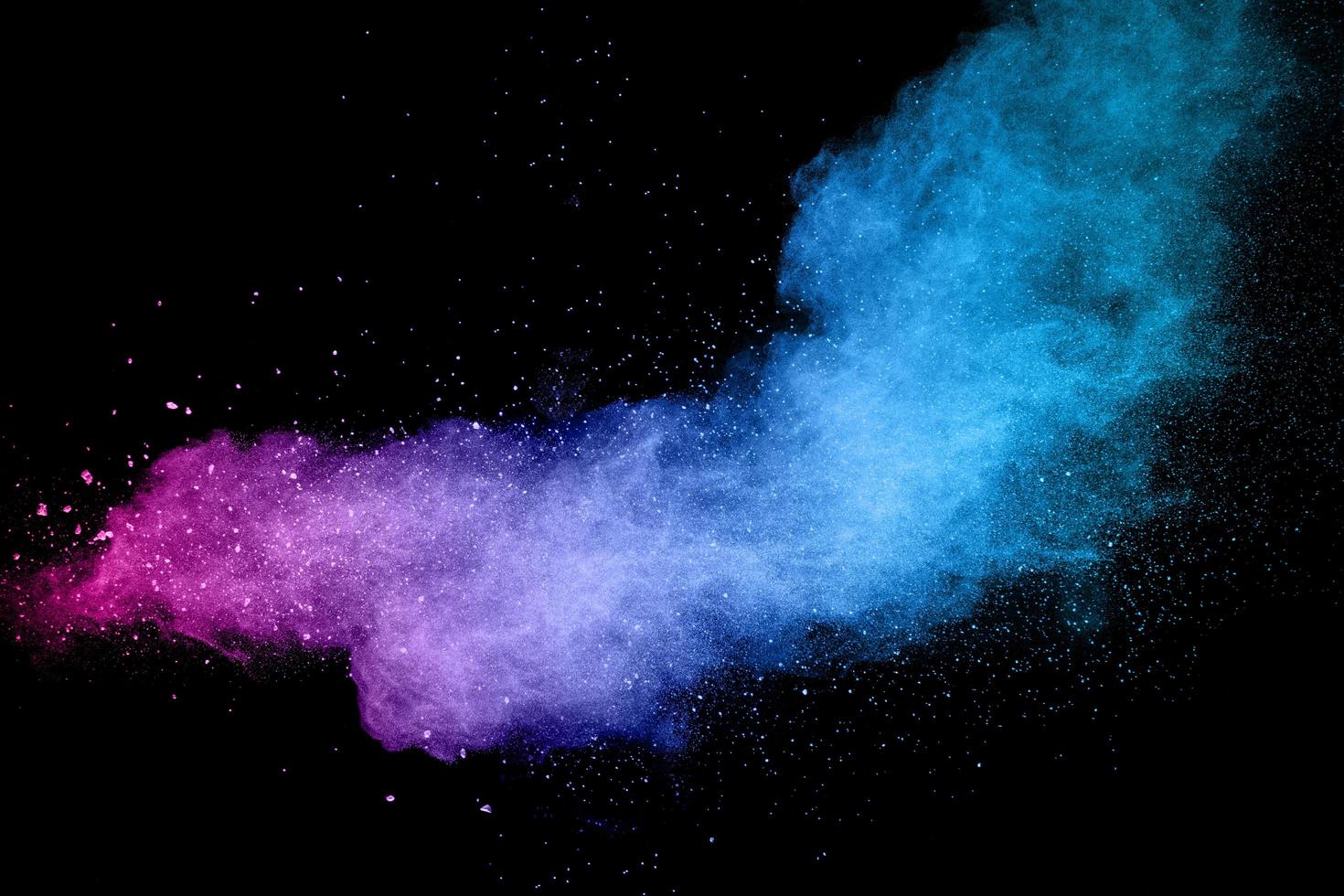 Explosion of color powder on black background. Splash of color powder dust on dark background. photo