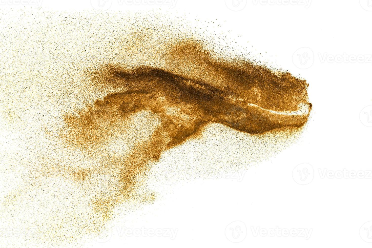 Dry river sand explosion. Golden colored sand splash agianst white background. photo