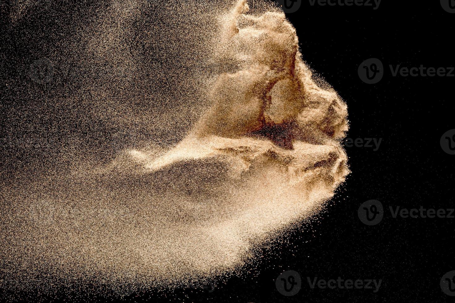 Dry river sand explosion. Golden colored sand splash agianst dark background. photo