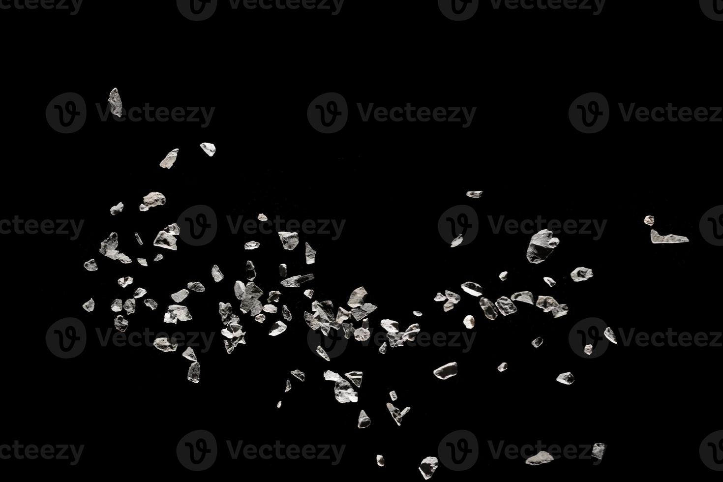 Split debris of stone exploding against black background. photo