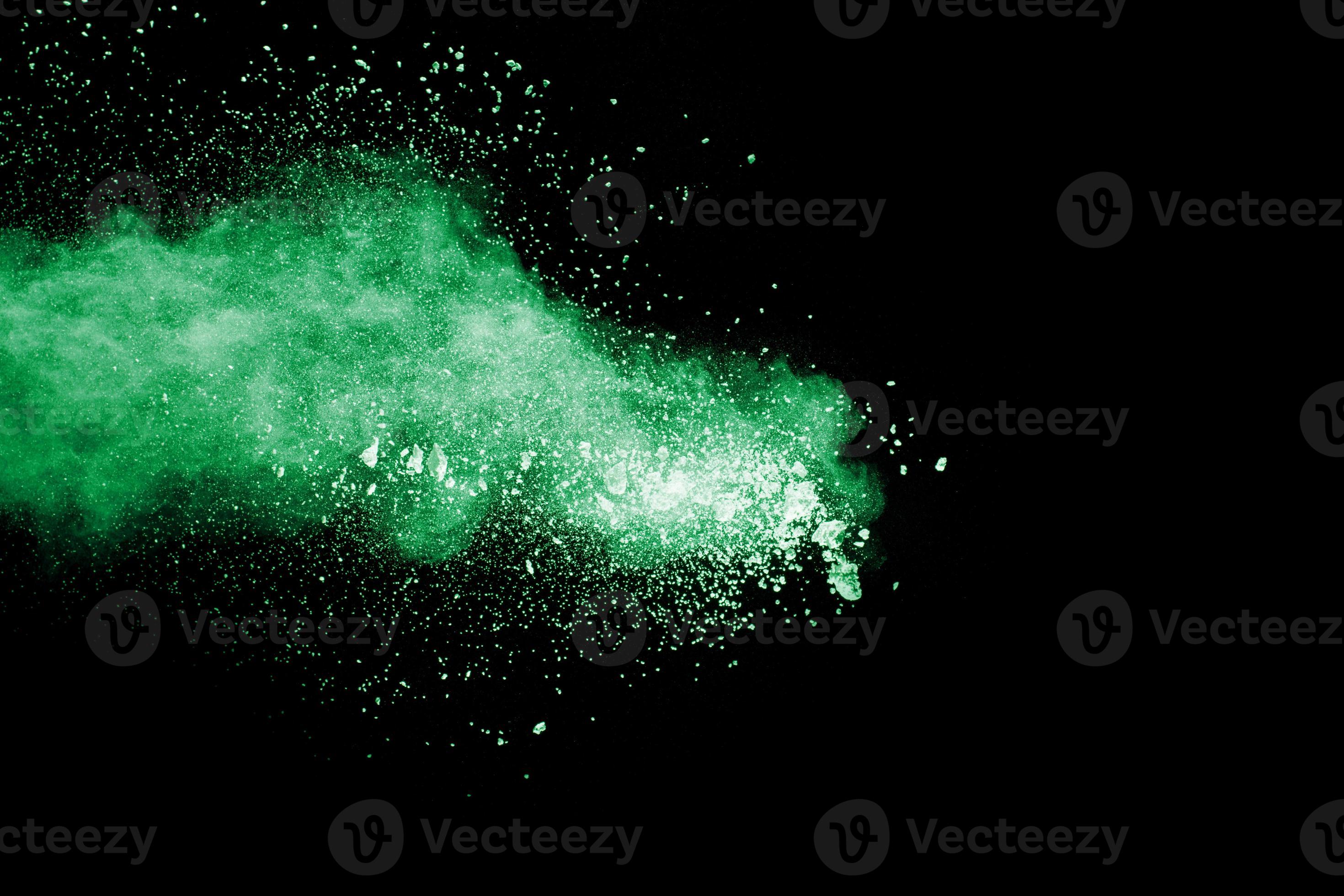 Green color powder explosion cloud on black background.Green dust