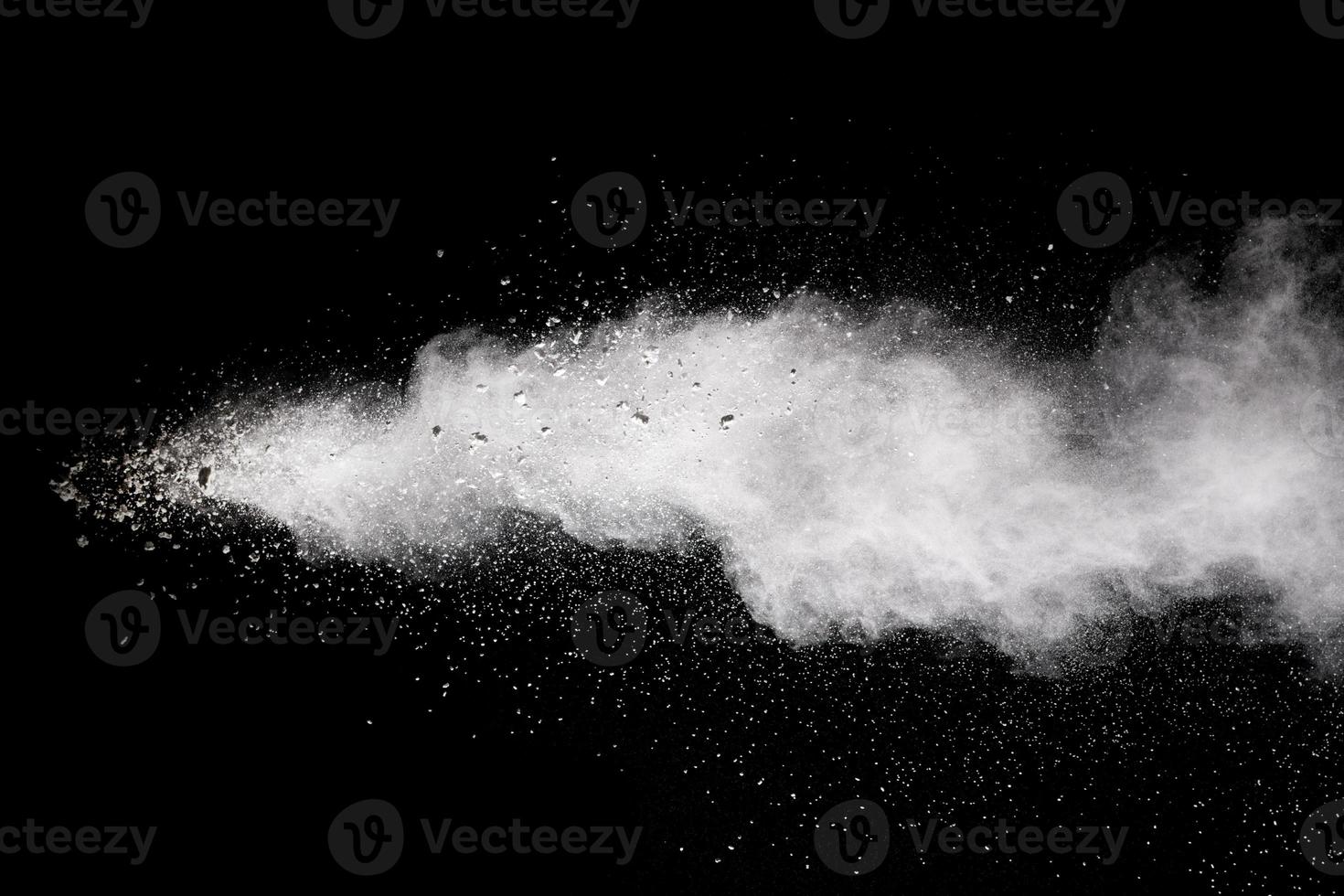 Bizarre forms of white powder explosion cloud against black background.White dust particles splash. photo