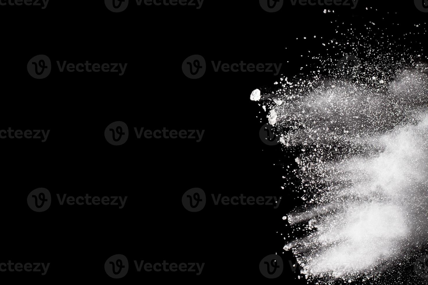 Bizarre forms of white powder explosion cloud against black background.White dust particles splash. photo