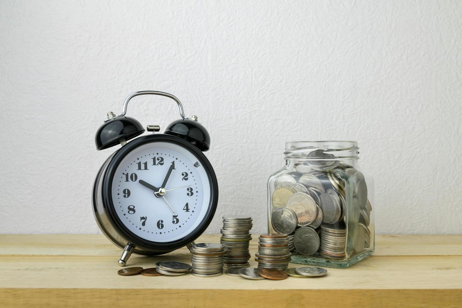 clock and stacks of coins for business money concept photo
