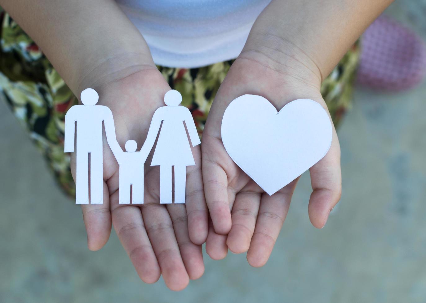 Children hands holding small model of heart and family , concept family photo