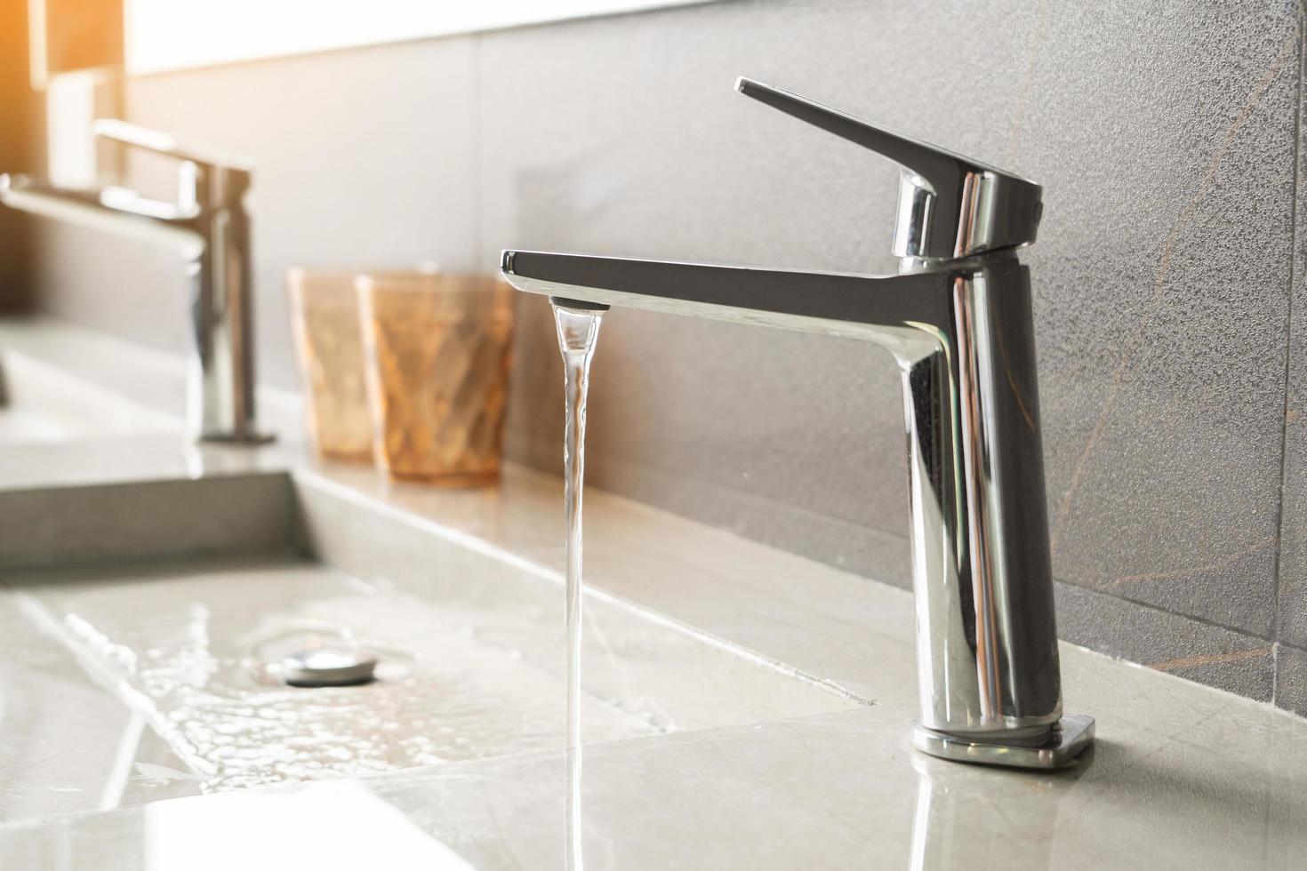 Basin faucet and Water running from a Stainless steel water tap in bathroom,save energy concept photo