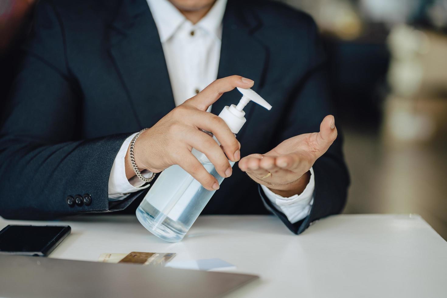 Business man washing hands with alcohol gel or antibacterial soap sanitizer after using a public restroom.Hygiene concept. prevent the spread of germs and bacteria and avoid infections corona virus photo