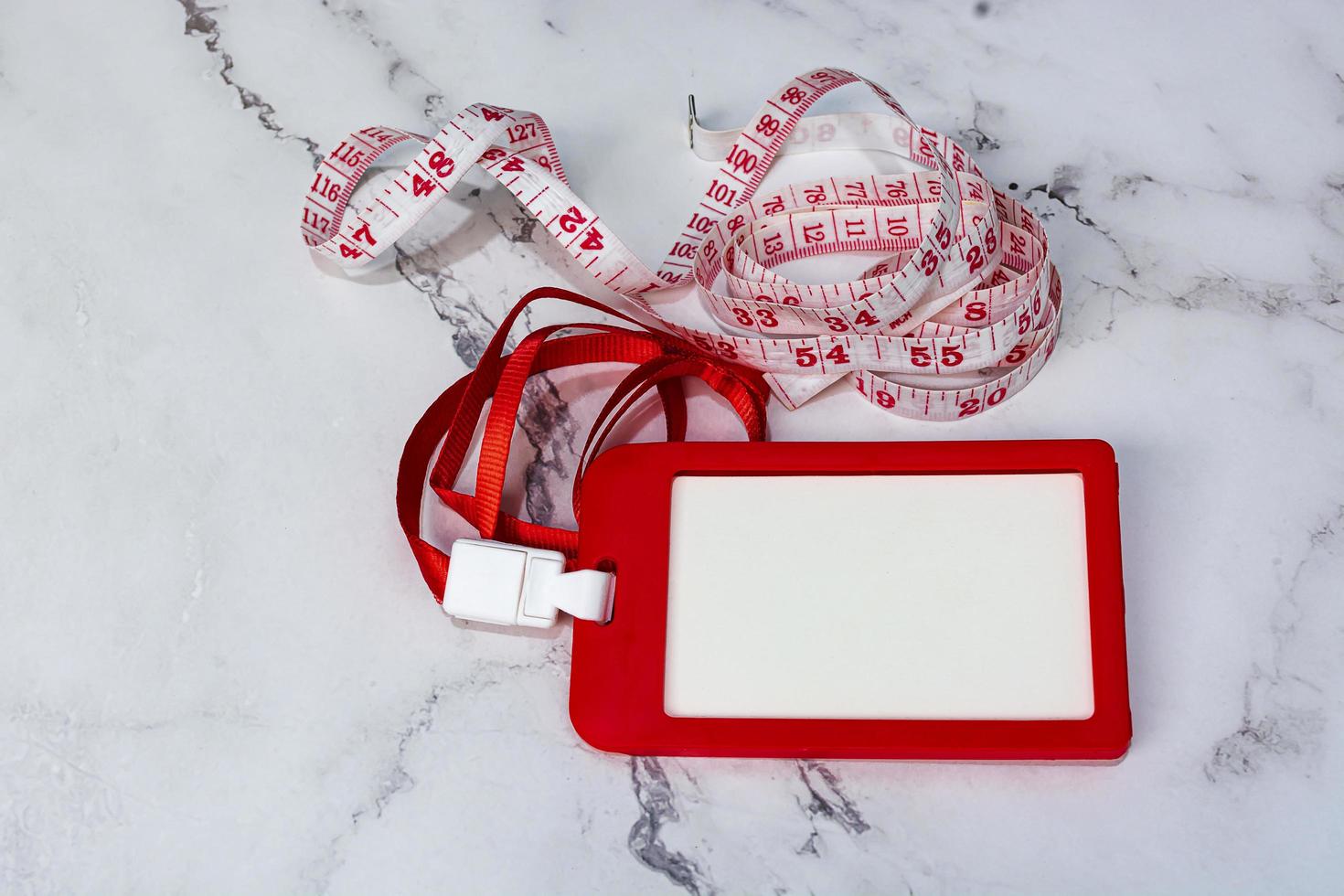 Red name tag with measure tap on white desk. Healthy and diet concept. photo