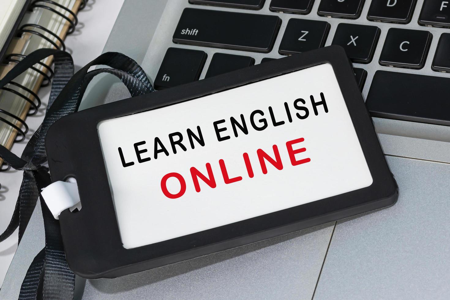 Learn english online text written on black name tag placed on a laptop. photo