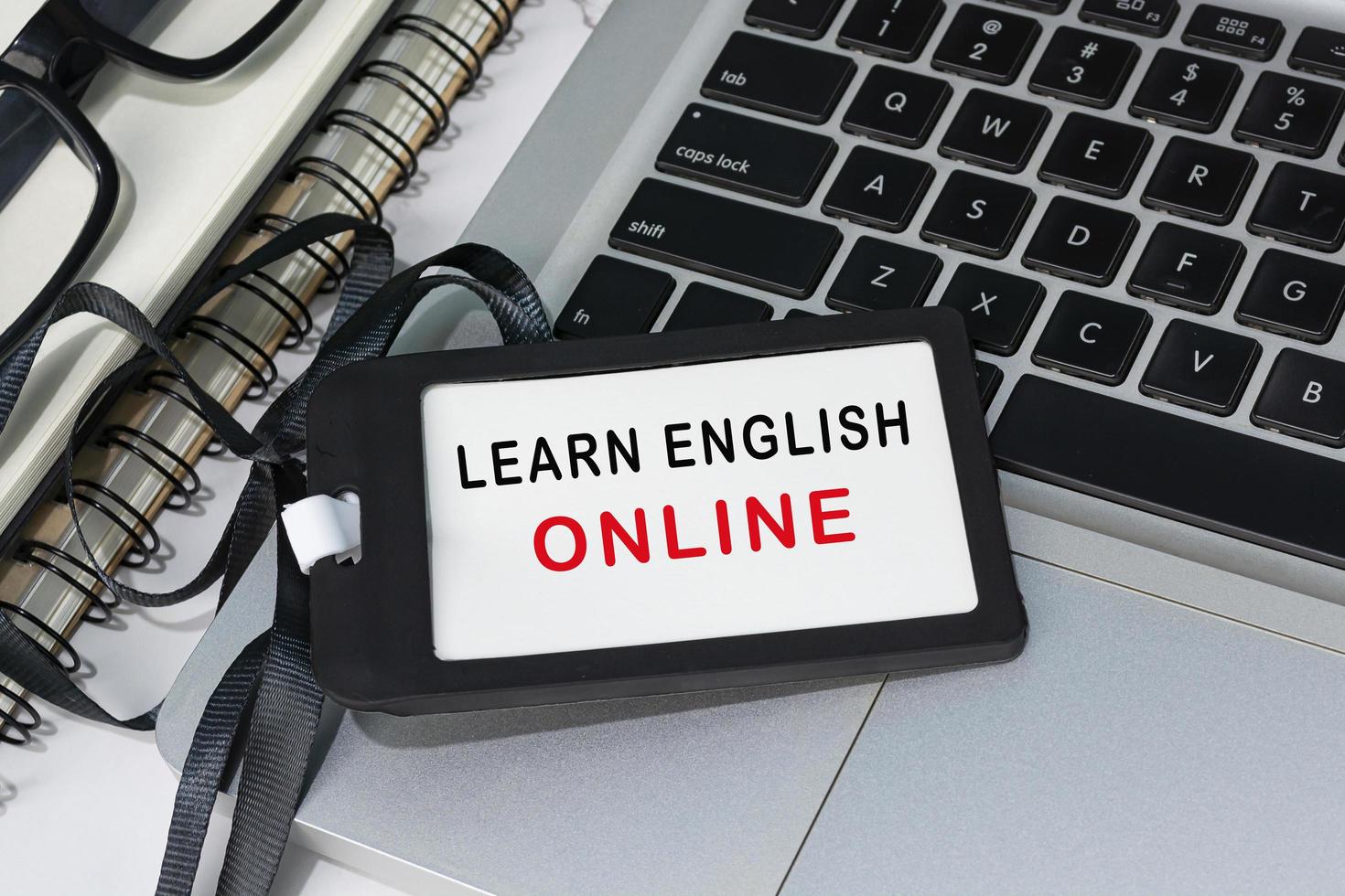 Learn english online text written on black name tag placed on a laptop. photo