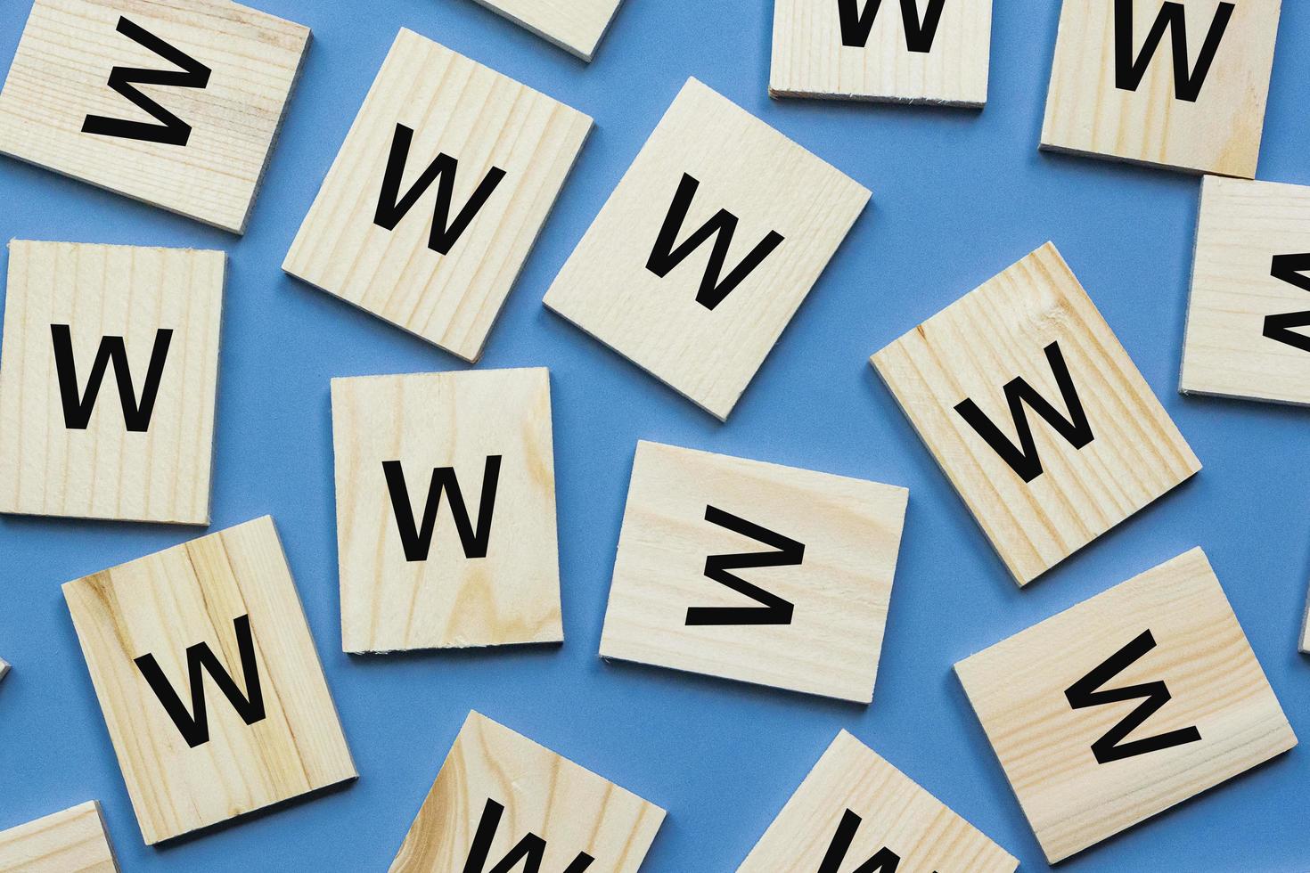 Alphabet W on wooden block lay flat on blue background. 5Ws concept photo