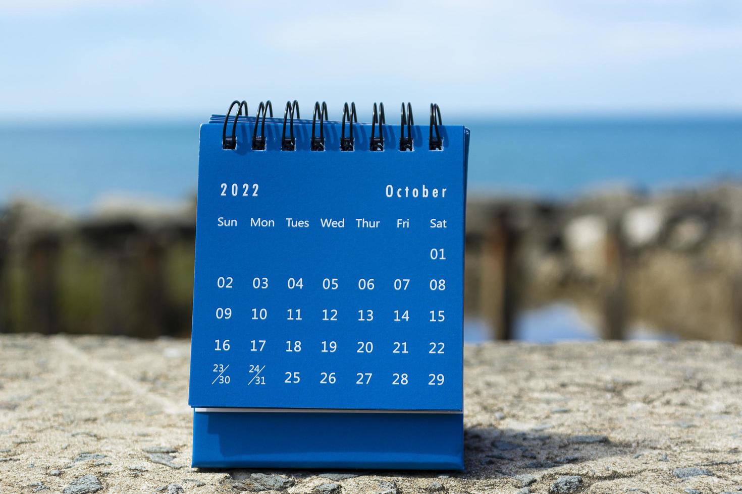 Blue October 2022 calendar on blurred background of blue ocean photo