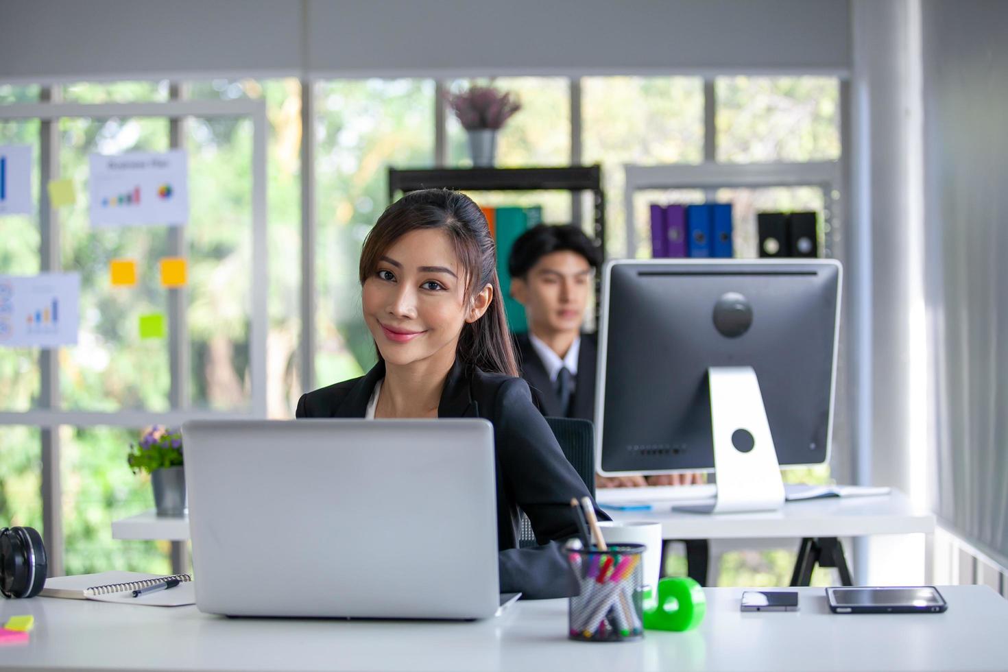 Portrait of Asian beautiful business woman working at the office, using computer on table. photo