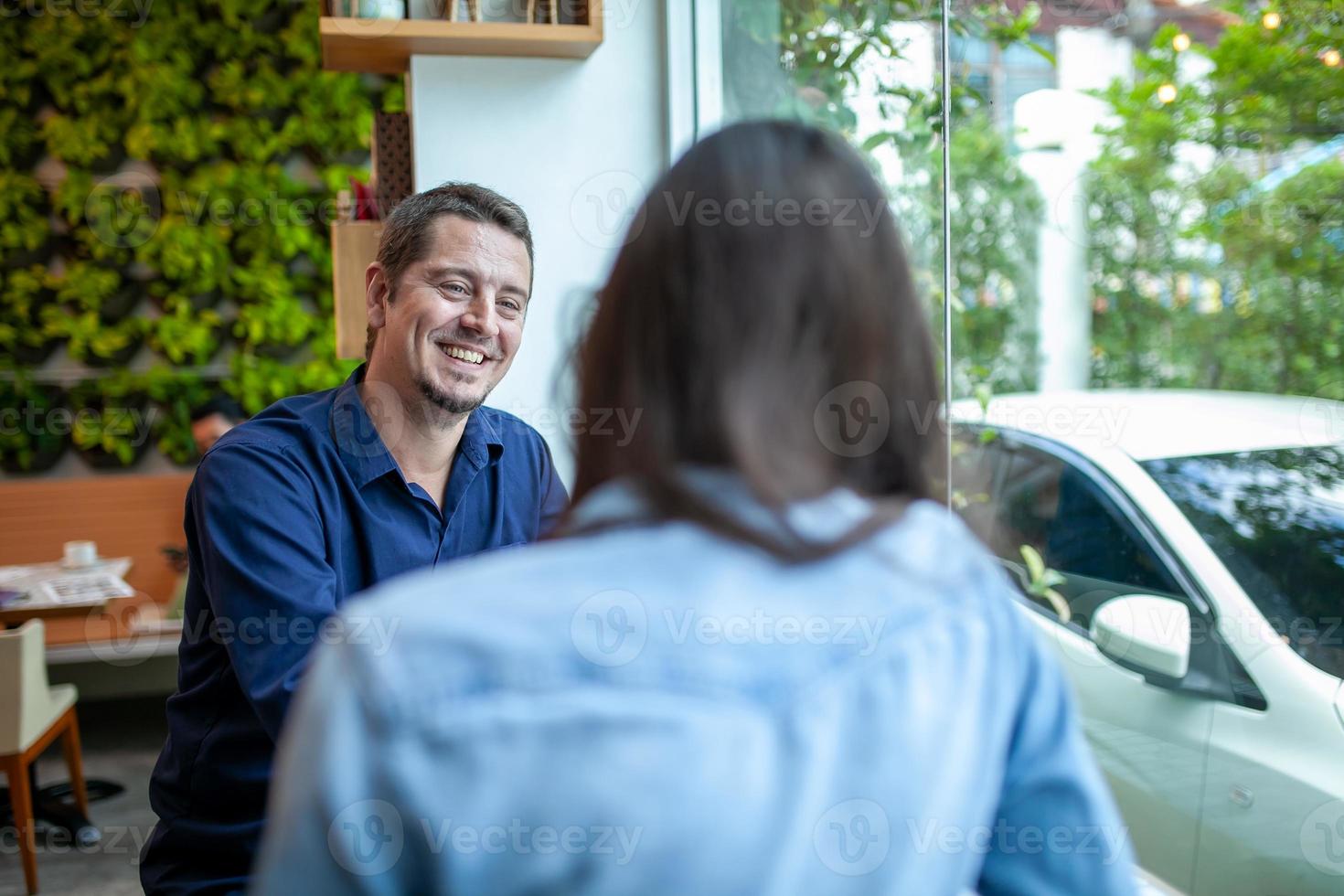 colegas hablando y usando portátiles trabajan juntos en la cafetería. foto