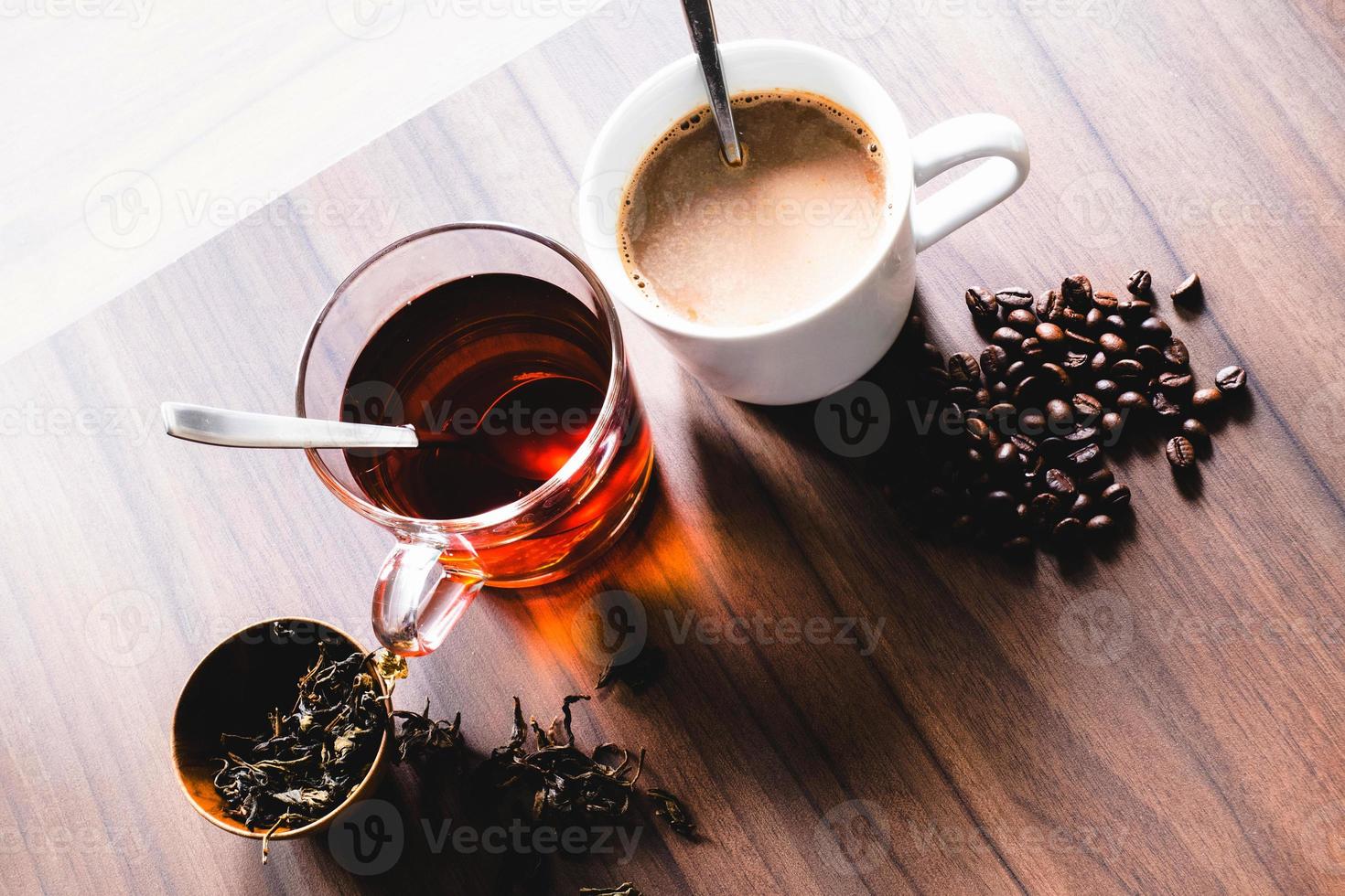 Coffee and tea with coffee bean and tea leaves on wooden floor. photo