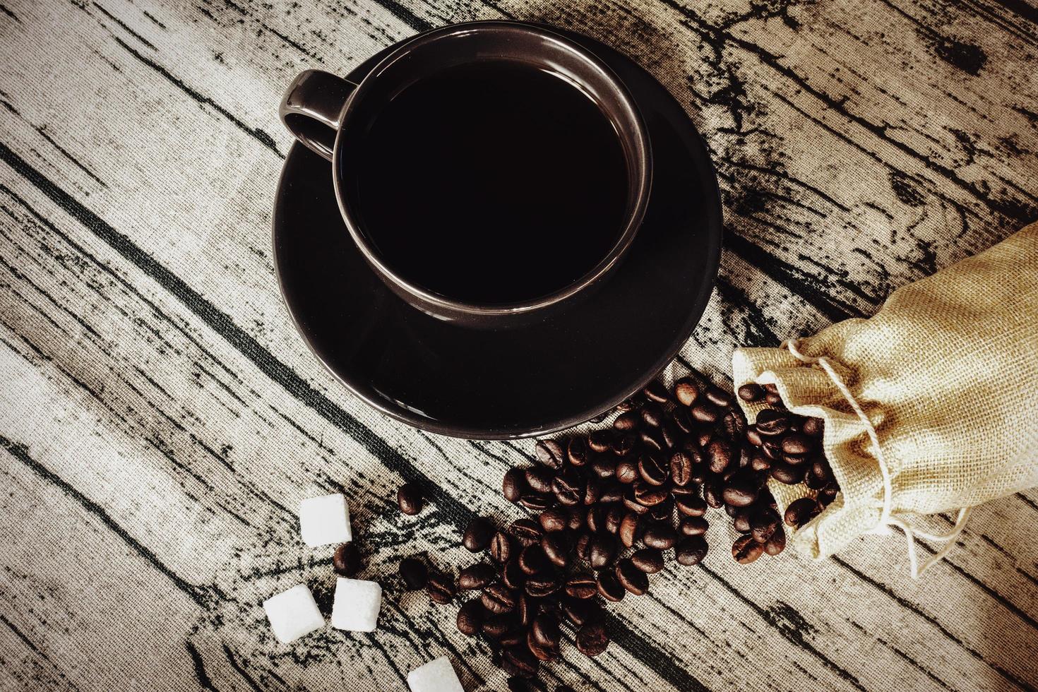 Cup of coffee with beans on a wooden table linen fabric. photo