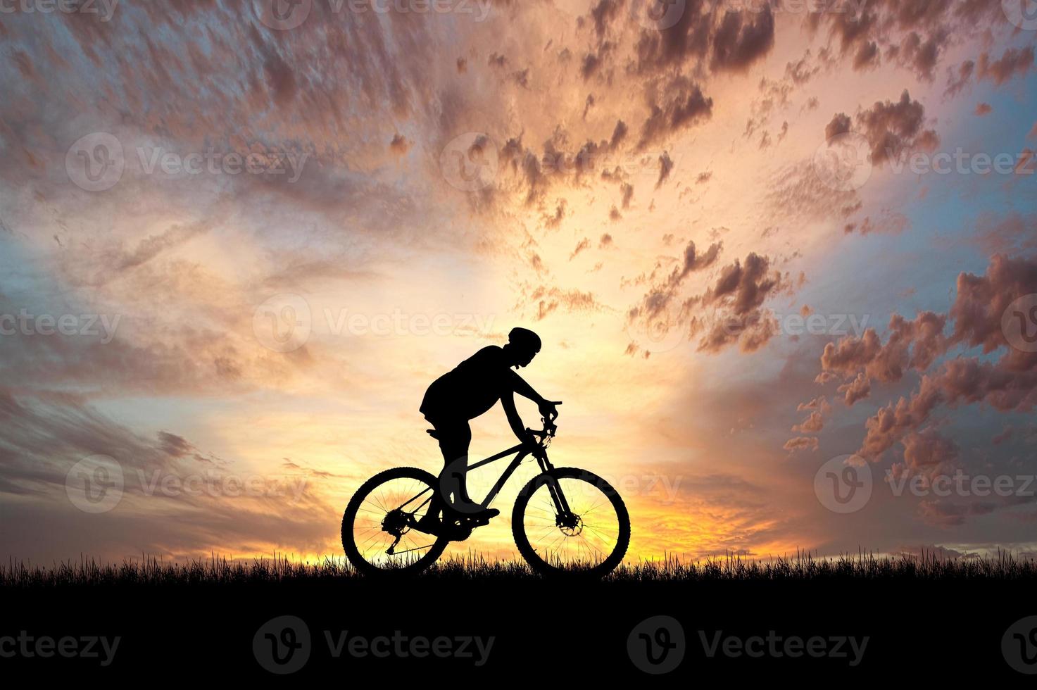 Silhouette of a cyclist in a beautiful evening meadow. bike vacation ideas photo