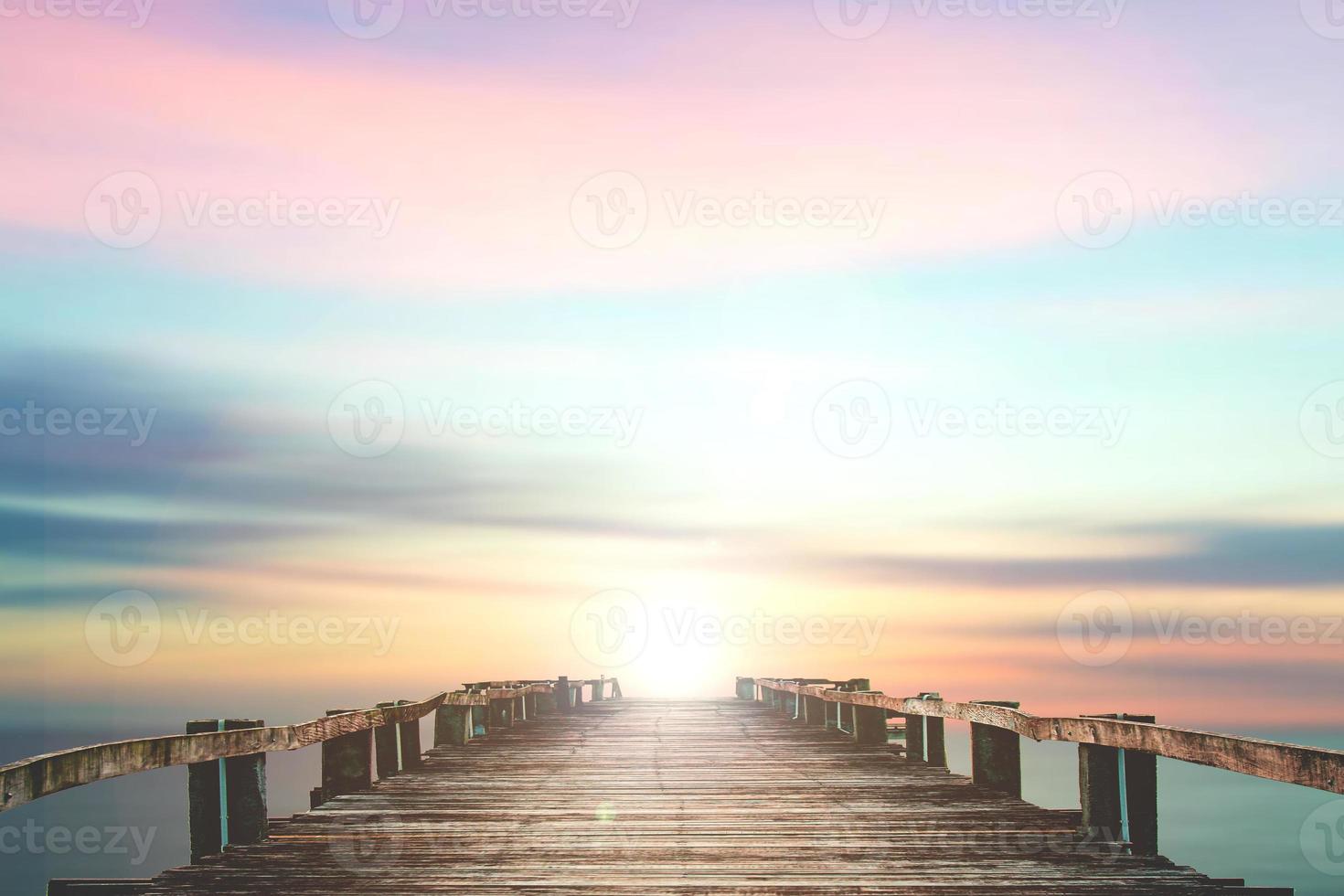 A wooden bridge jutting out into the sea with a beautiful view. photo