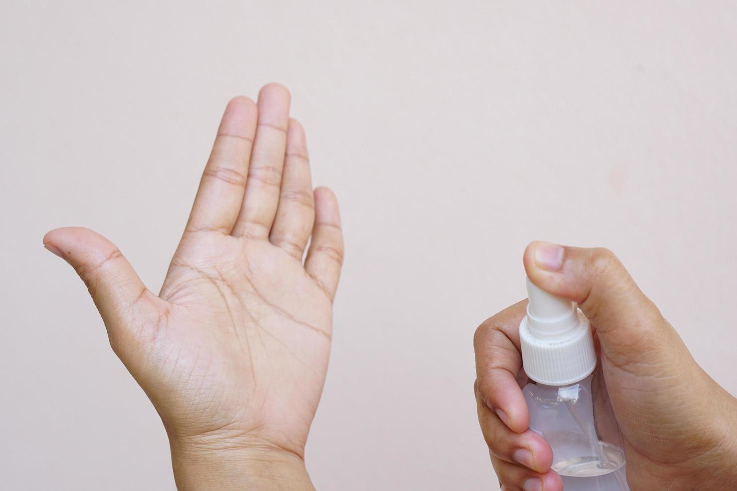 Women's hands using alcohol spray or antibacterial spray to prevent the spread of germs, bacteria and viruses. photo