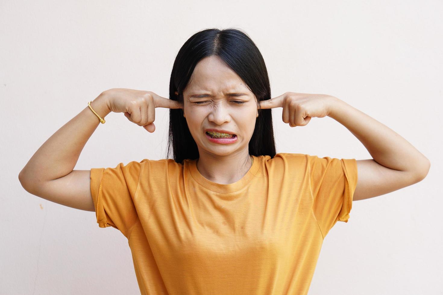 woman covered his ears over gray background photo