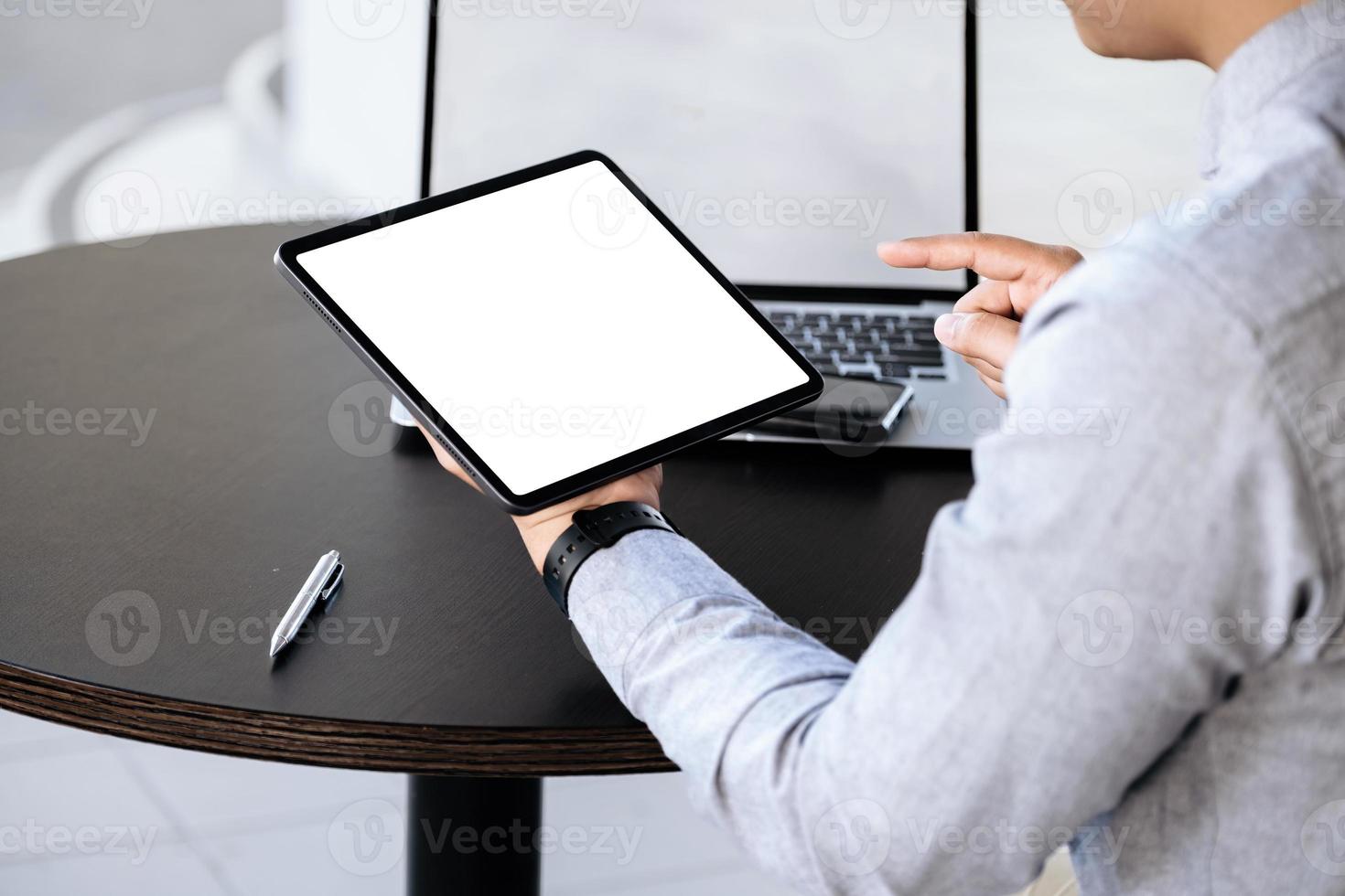 A man holding a tablet with a blank white screen. The blank space on the white screen can be used to write a message or place an image. photo