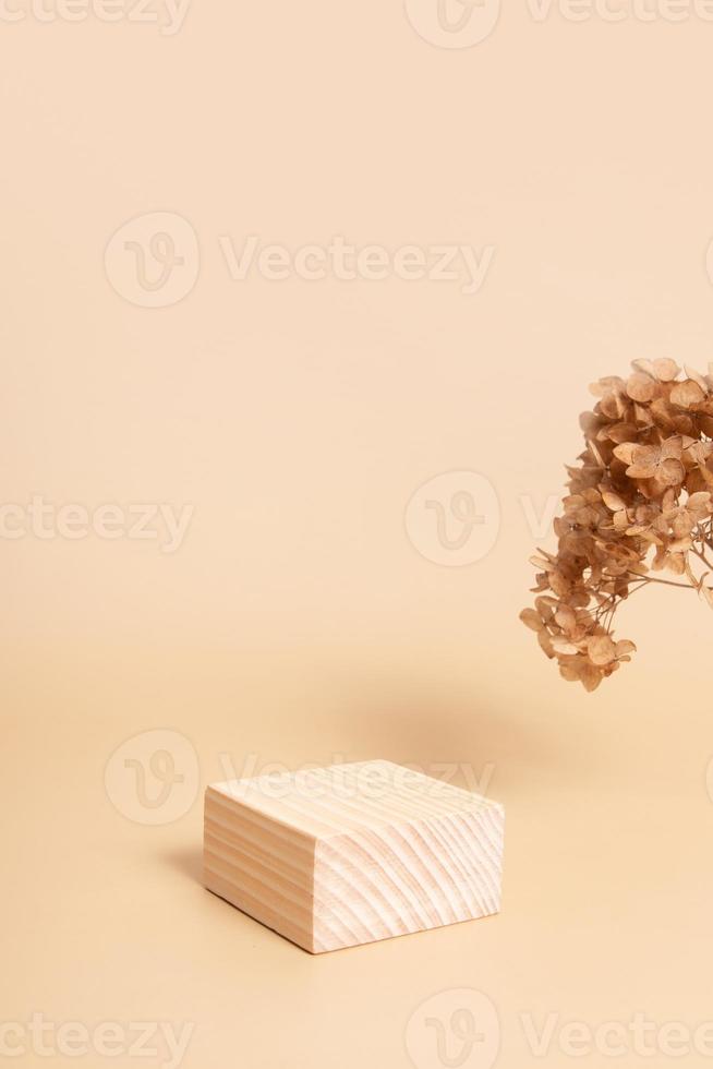 Wooden podium or pedestal for cosmetics, perfumes or jewelry. Neutral beige monochrome with dry flowers mok ap, blank photo