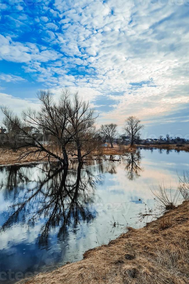 paisaje del norte a principios de primavera. aguas altas, campo pantanoso. turismo ecológico. los árboles y el cielo azul se reflejan en el agua. foto