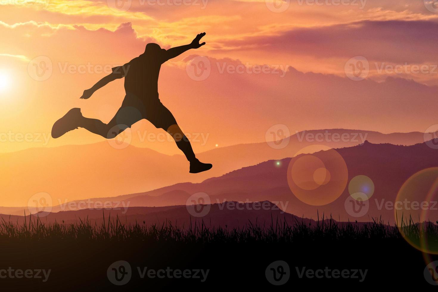 The silhouette of a man is jumping forward. The concept of clawing through hurdles photo
