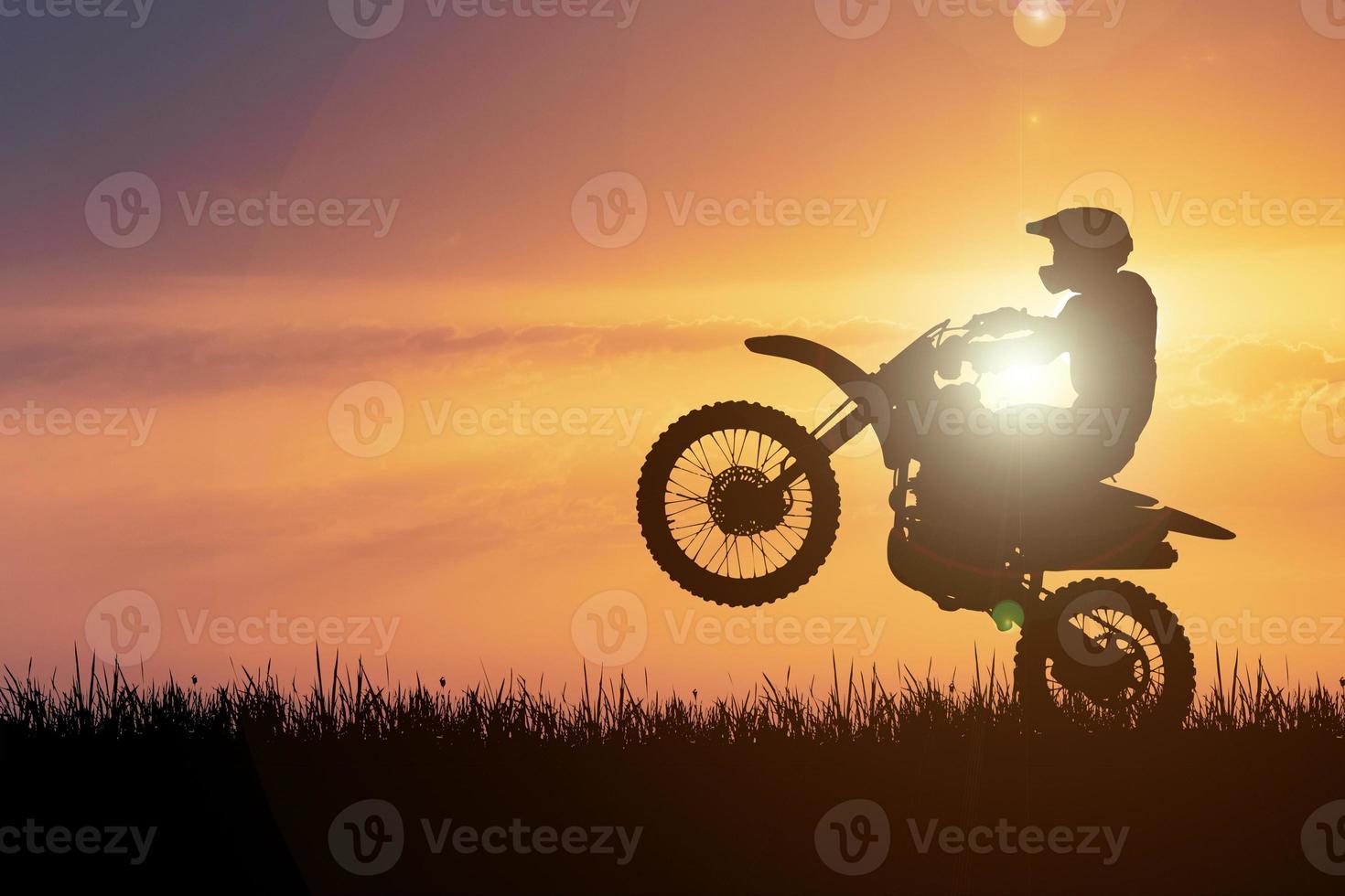 Silhouette of a motocross motorcycle lifting the front wheel. Adventure and Action Concepts photo