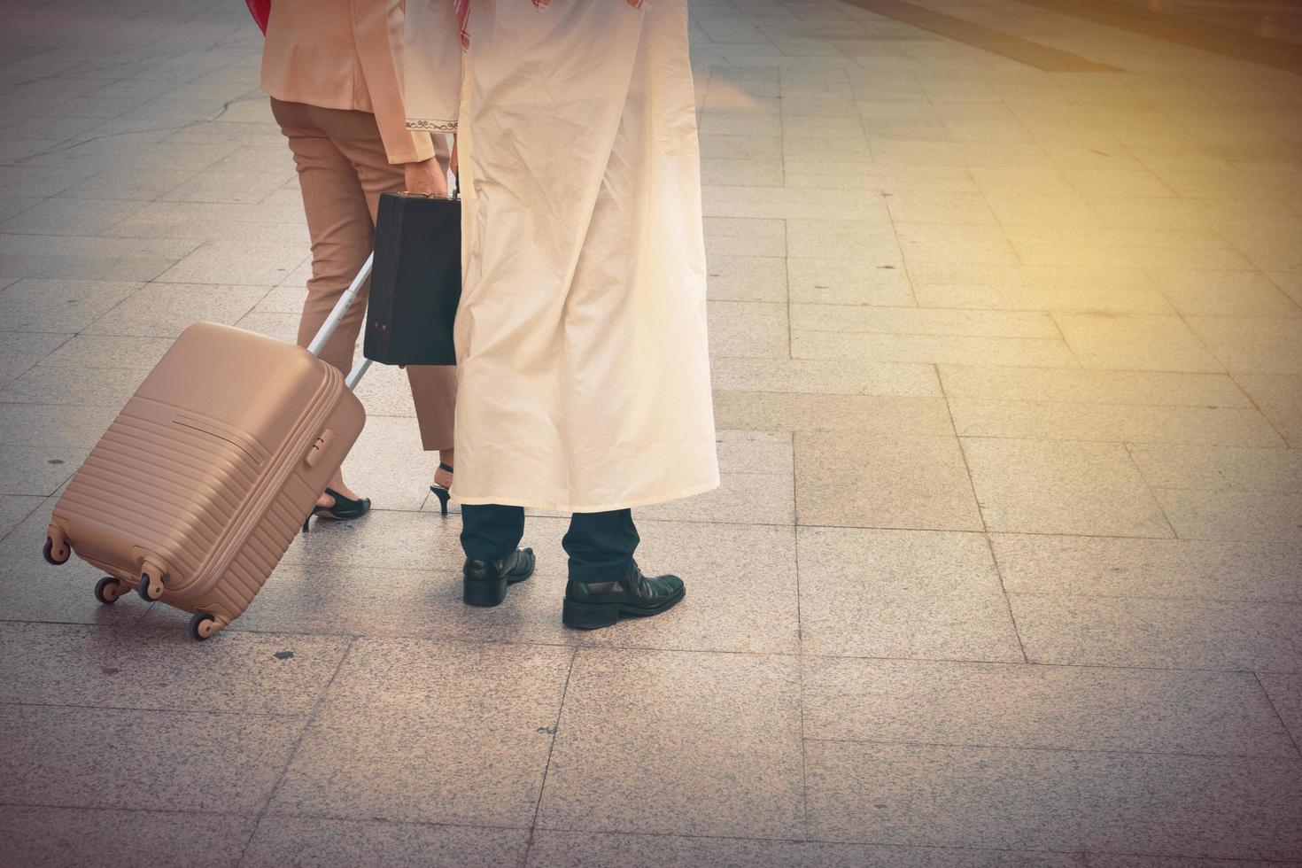 Arab man and woman walking carrying a suitcase photo