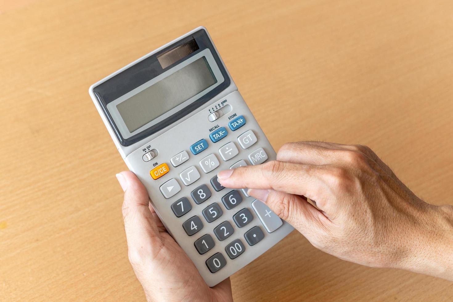 Man hands holding and using a calculator photo