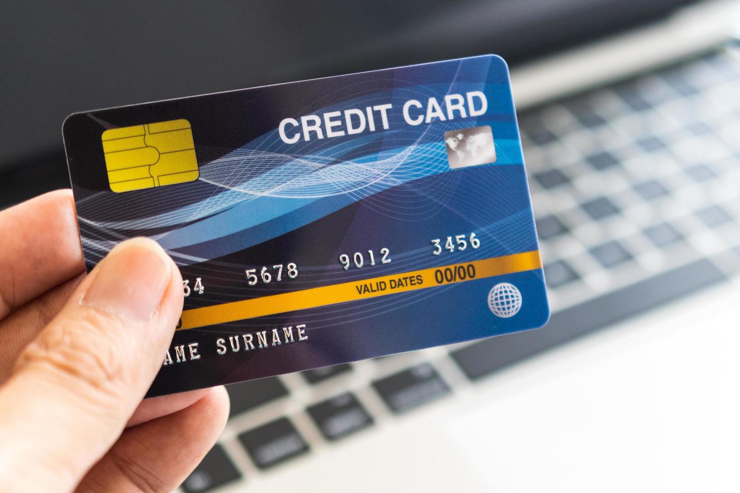 Man holding credit card on laptop. On-line shopping on the internet using a laptop photo