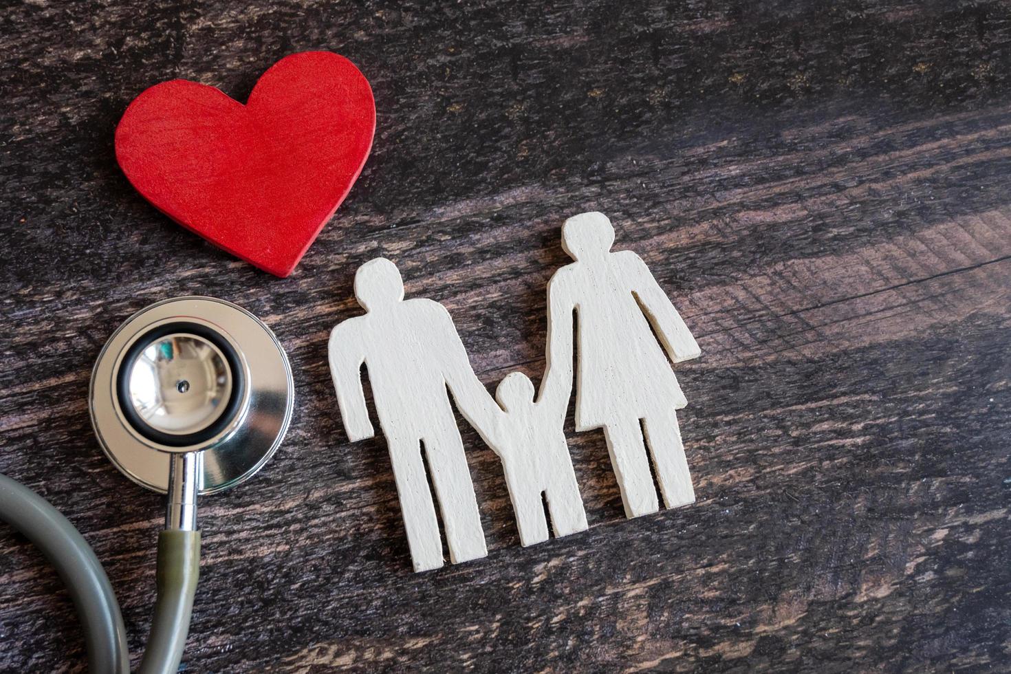 Red heart, stethoscope and icon family on wooden desk. Medical Insurance Concept photo