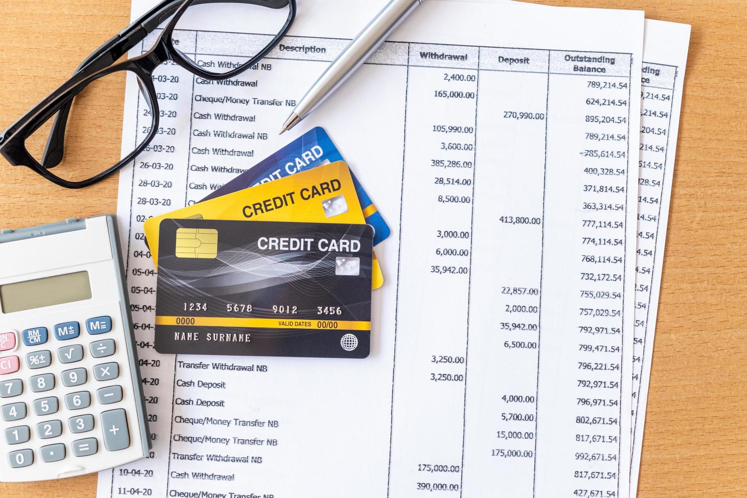 tarjetas de crédito y calculadora en extracto bancario en una mesa de madera foto